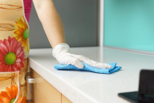Person cleaning kitchen surfaces during move out cleaning